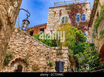 Stone exterior of old buildings with flowers on the streets of Eze Village, picturesque medieval city in South of France along the Mediterranean Sea Stock Photo