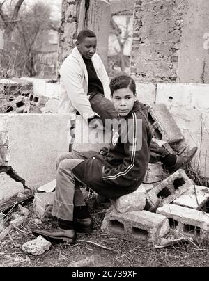 1960s TWO DISAFFECTED PRE-TEEN AFRICAN AMERICAN BOYS SITTING ON CONCRETE BLOCKS IN PILE OF URBAN RUBBLE PHILADELPHIA PA USA - n1951 HAR001 HARS POOR HEALTHINESS HOME LIFE UNITED STATES COPY SPACE FRIENDSHIP FULL-LENGTH UNITED STATES OF AMERICA MALES RISK TEENAGE BOY SIBLINGS B&W SADNESS NORTH AMERICA FREEDOM NORTH AMERICAN TEMPTATION DREAMS WELLNESS STRATEGY AFRICAN-AMERICANS COURAGE AFRICAN-AMERICAN PA POWERFUL BLACK ETHNICITY PRIDE IN OF ON OPPORTUNITY SIBLING CONCEPTUAL ESCAPE DISADVANTAGED DISAFFECTED DISAPPOINTED DISCONNECTED GROWTH IMPOVERISHED JUVENILES PRE-TEEN PRE-TEEN BOY Stock Photo