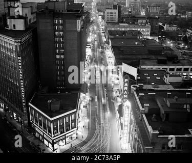 1930s 1940s LOOKING DOWN CITY STREET PEDESTRIANS TROLLEY CARS NEON SIGNS AT NIGHT FROM THE CANDLER BUILDING ATLANTA GEORGIA USA - r13017 PUN001 HARS HIGH ANGLE PROPERTY AUTOS EXCITEMENT EXTERIOR RECREATION AT THE SOUTHERN TROLLEY REAL ESTATE CONCEPTUAL STRUCTURES AUTOMOBILES STYLISH VEHICLES EDIFICE BLACK AND WHITE GA OLD FASHIONED Stock Photo