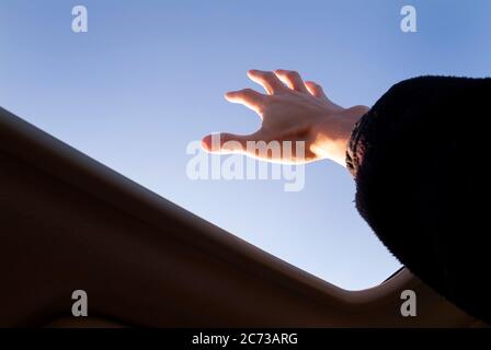 Hand reaching for sunshine. Stock Photo