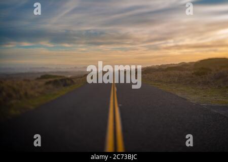 Selectively blurred road and horizon with sunset sky. Stock Photo