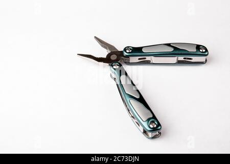 Multitool with pliers on white background. Top view. Tools for cutting, sawing, screwing, compressing and other. Stock Photo