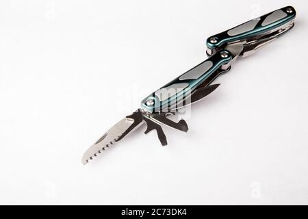 Multitool with green and grey handles on white background. Tools for cutting, sawing, screwing, compressing, bottle opening and other purposes. Stock Photo