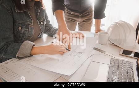 Architects are discussing and planning together at the desk with blueprints.construction & building concept. Stock Photo