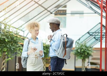 Multiethnic business colleagues talking to each other while have meeting at office building Stock Photo