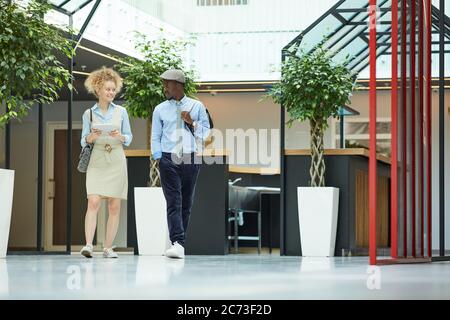 Young business people walking together along the office corridor they finished their work Stock Photo