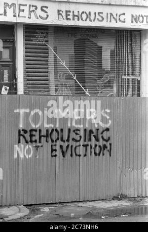 Hand-painted slogans on corrugated iron fencing at Tolmers Square, Somers Town, London, England, UK, during the protests there in the late 1970s. Located in Somers Town, near Euston station in central London, Tolmers Square was occupied by more than one hundred squatters in the 1970s, who, along with local groups, fought for a redevelopment plan which fitted the local community. By 1975, 'Tolmers Village' had 49 squats housing over 180 people. The squatters lived there for six years. Many of the proposals by the protesters resulted in building housing instead of offices at Tolmers Square. Stock Photo