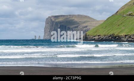 Risin and Kellingin rocks as seen from Tjornuvik bay with waves hitting the shore on Streymoy on the Faroe Islands, Denmark, Europe Stock Photo
