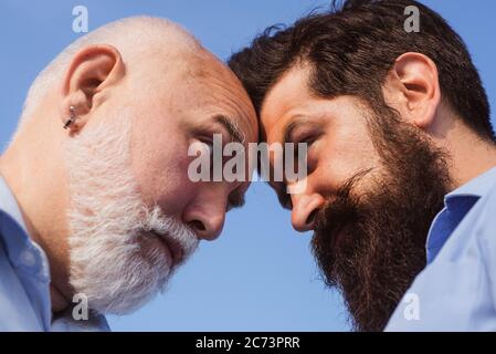 Man looking at each other - close up portrait. Man in different ages. Man vs concept. Old father and son. Senior vs man, confrontation and competition Stock Photo