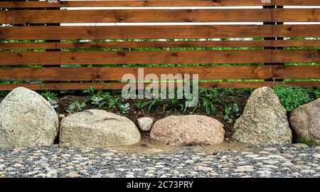 background of a wooden fence and a path made of stones Stock Photo