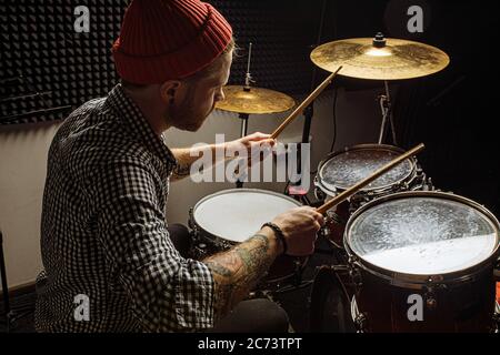 energetic caucasian drummer man professionally play on drums, he enjoy performing music in studio, preparing for concert. rock and roll, music, instru Stock Photo