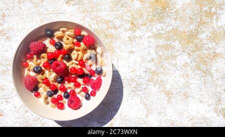 bowl of breakfast rings with milk and berries isolated on white background, top view.Delicious corn rings with berries on table.Healthy breakfast Stock Photo