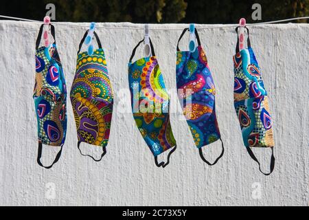 Colorful South African fabric face masks for Covid-19 protection hanging out to dry on a clothesline Stock Photo