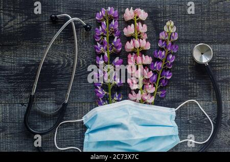 Summer healthcare concept.Stethoscope and flowers on dark wooden table Stock Photo