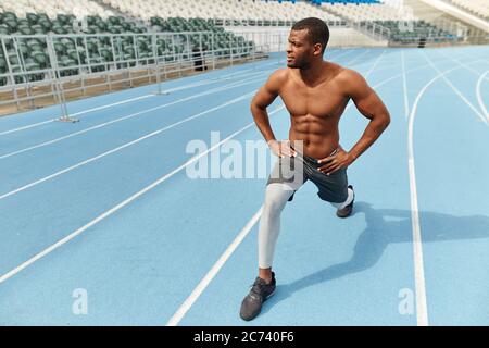 ambitious sportsman stretching legs before running outdoors. full length photo. free time, spare time, lifestyle Stock Photo