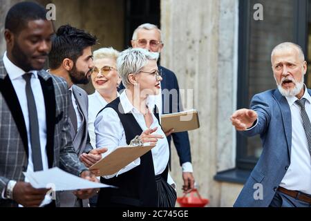 Group of businessmen wear stylish suits in the street give an ...