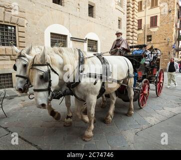 Florence, Italy - 04 November, 2017: tourists touring around in a horse carriage in the touristic city center. Stock Photo