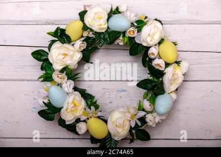 Easter background with spring easter eggs and flowers, wreath on door Stock Photo