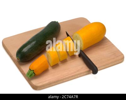 Two zucchini or courgettes on a wooden board and on white background Stock Photo