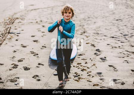 A young boy learning in body board outdoors in the shoreline in a sunny day of summer