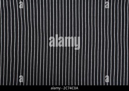 Black textured knitted fabric with white stripes. Vertical pattern Stock Photo