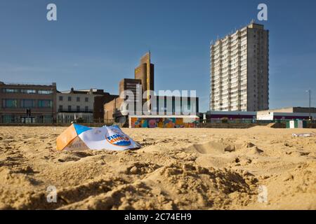 Discarded empty Fish and Chips box on the sand at Margate beach in Kent. Stock Photo