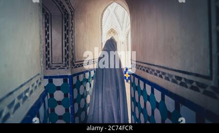 Kashan, Iran - May 2019: Unidentified Iranian woman in chador hijab walking inside of Sultan Amir Ahmad Qasemi Bath house Stock Photo