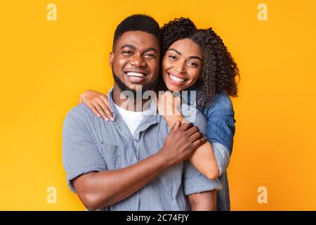 Portrait Of Cheerful African American Couple Posing To Camera Over Yellow Background Stock Photo
