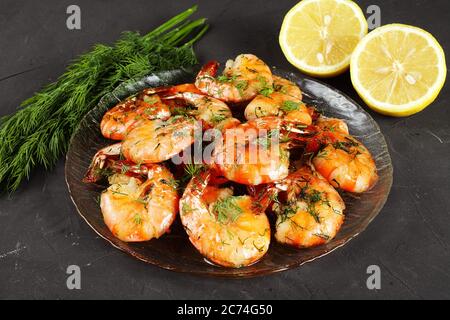 fried king prawns in a plate, lemon, dill, close-up Stock Photo