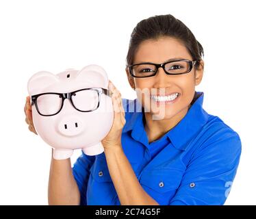 Portrait of a young smiling woman wearing glasses holding piggy bank, isolated on white background. Stock Photo