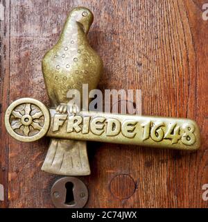 door handle in form of a dove with lettering Friede 1648, Peace of Westphalia on the town hall of Osnabrueck, Germany, Lower Saxony, Osnabrueck Stock Photo