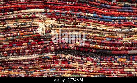 Isfihan, Iran - May 2019: Pile of traditional Iranian carpet and rugs in a carpet shop Stock Photo