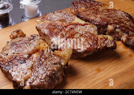 three fried marbled beef steaks on a cutting board, close-up Stock Photo