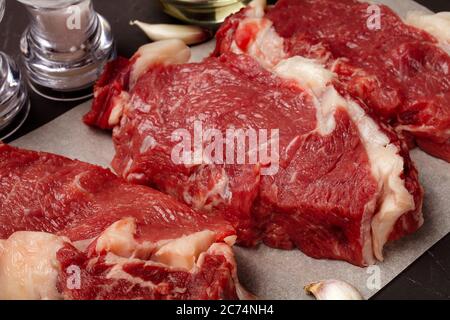 three steaks of raw marbled beef on the table, close-up Stock Photo