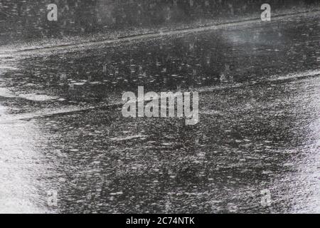 Raindrops on asphalt closeup, background or texture Stock Photo