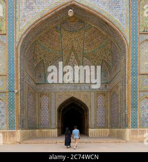 Shiraz, Iran - May 2019: Unidentified couple walking towards the prayer hall of Vakil Mosque, Shabestan. Vakil means regent, title of Karim Khan, foun Stock Photo