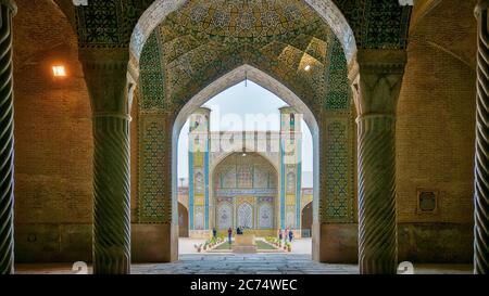 Shiraz, Iran - May 2019: Tourists in courtyard of Vakil Mosque as seen from the hall of prayer. Vakil means regent, title of Karim Khan, founder of Za Stock Photo