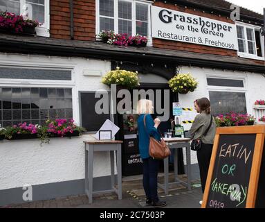 Westerham,Kent,UK,14th July 2020,People queue outside Grasshopper on the Green Restaurant & Freehouse on Westerham Green in Kent. The weather forecast is 18C and partly cloudy and to is forecast to improve as the week continues.Credit: Keith Larby/Alamy Live News Stock Photo