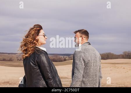 Young modern stylish couple outdoors. Woman in leather jacket and men with beard Stock Photo