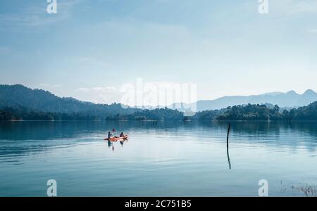 Mother and son floating on kayak together on calm water of Cheow Lan lake in Thailand Stock Photo