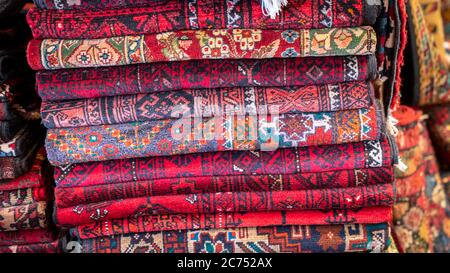 Isfihan, Iran - May 2019: Pile of traditional Iranian carpet and rugs in a carpet shop Stock Photo