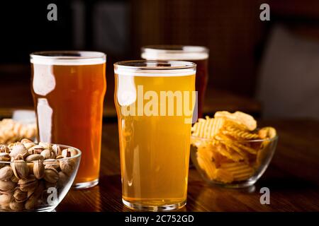 Set for the client. Unfiltered, barley and dark beer with snacks in interior Stock Photo