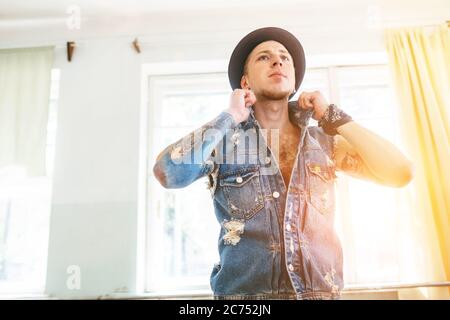 Dancer man in denim jacket posing in dance hall Stock Photo