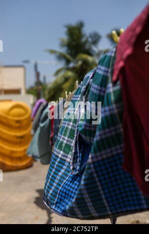 wet laundry drying on clothes line against a blue sky background Stock Photo