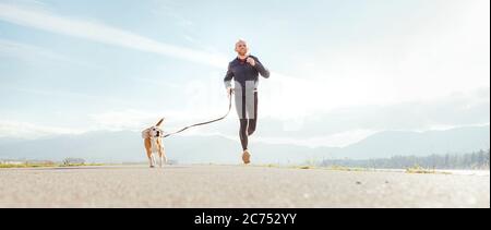 Running man with his dog . Active healthy lifestyle concept image. Stock Photo