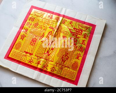 Gold Chinese joss paper aka ghost money, spirit money or hell bank notes which is used for ancestral worship or prayer Stock Photo