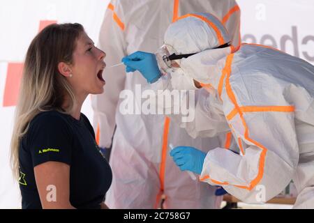 Dippoldiswalde, Germany. 14th July, 2020. Antonia Werthmann (l), THW helper, is being tested with a swab by an employee of the German Red Cross (DRK) in protective clothing on the occasion of a press appointment in a mobile Covid-19 sampling station. The station is intended to ensure that suspected Covid-19 cases can be tested in the Free State of Bavaria. Credit: Sebastian Kahnert/dpa-Zentralbild/dpa/Alamy Live News Stock Photo
