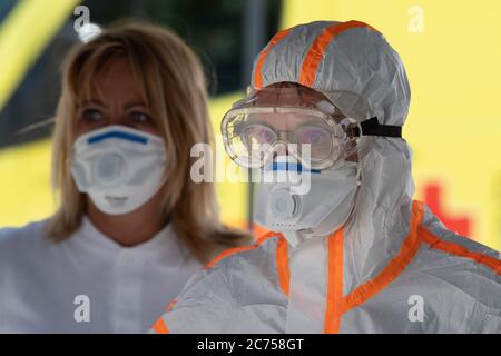 Dippoldiswalde, Germany. 14th July, 2020. Two employees of the German Red Cross (DRK) in protective clothing stand side by side in a mobile Covid-19 sampling station on the occasion of a press event. The station is intended to ensure a location-independent test of suspected Covid-19 cases in the Free State. Credit: Sebastian Kahnert/dpa-Zentralbild/dpa/Alamy Live News Stock Photo