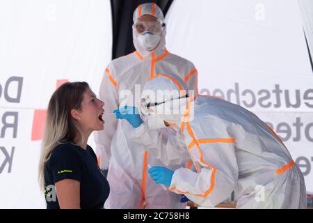 Dippoldiswalde, Germany. 14th July, 2020. Antonia Werthmann (l), THW helper, is being tested with a swab by an employee of the German Red Cross (DRK) in protective clothing on the occasion of a press appointment in a mobile Covid-19 sampling station. The station is intended to ensure that suspected Covid-19 cases can be tested in the Free State of Bavaria. Credit: Sebastian Kahnert/dpa-Zentralbild/dpa/Alamy Live News Stock Photo