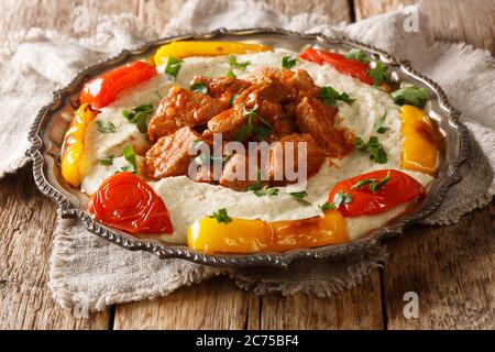 Turkish lamb AliNazik kebab in red sauce with aubergine puree closeup in the plate on the table. Horizontal Stock Photo